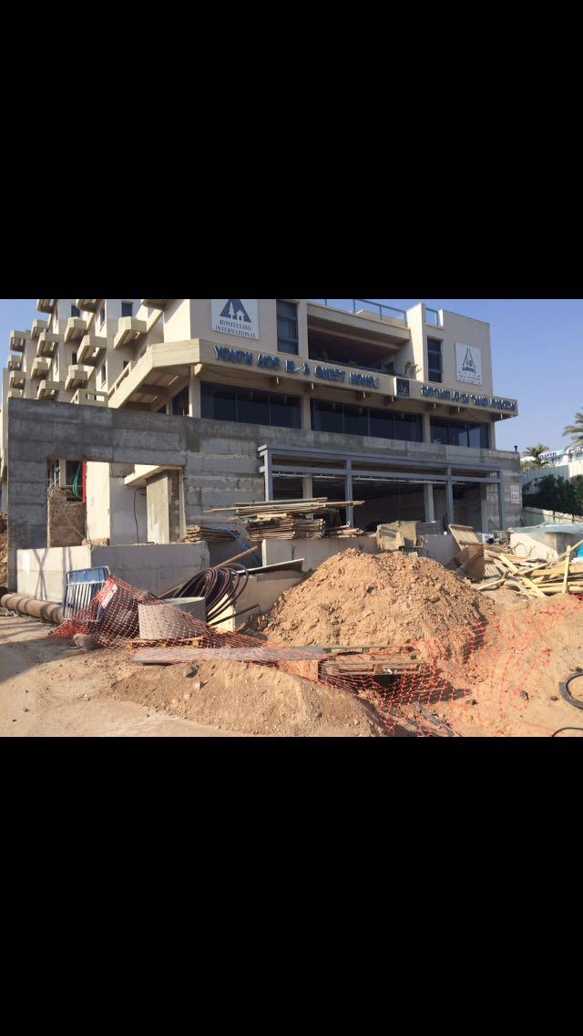 חיפוי חזית וקורת מבנה-הכנה לשלט, אכסניית הנוער באילת