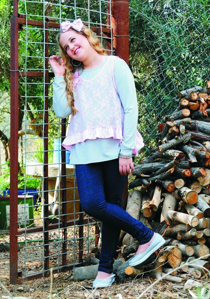 שחר בחולצה אפורה עם עליונית תחרה ורודה וטייץ סקיני ג'ינס כחול