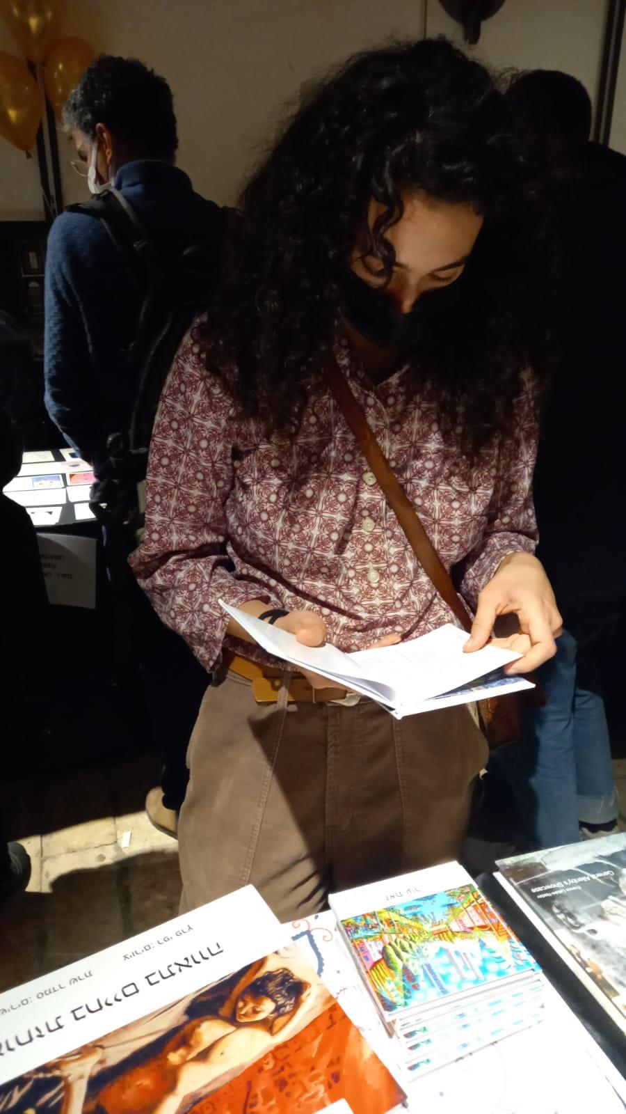 מתבוננים בספרים בדוכן היריד יריד ספר אמן בית הנסן ירושלים דוכני ספרים in print art book fair books